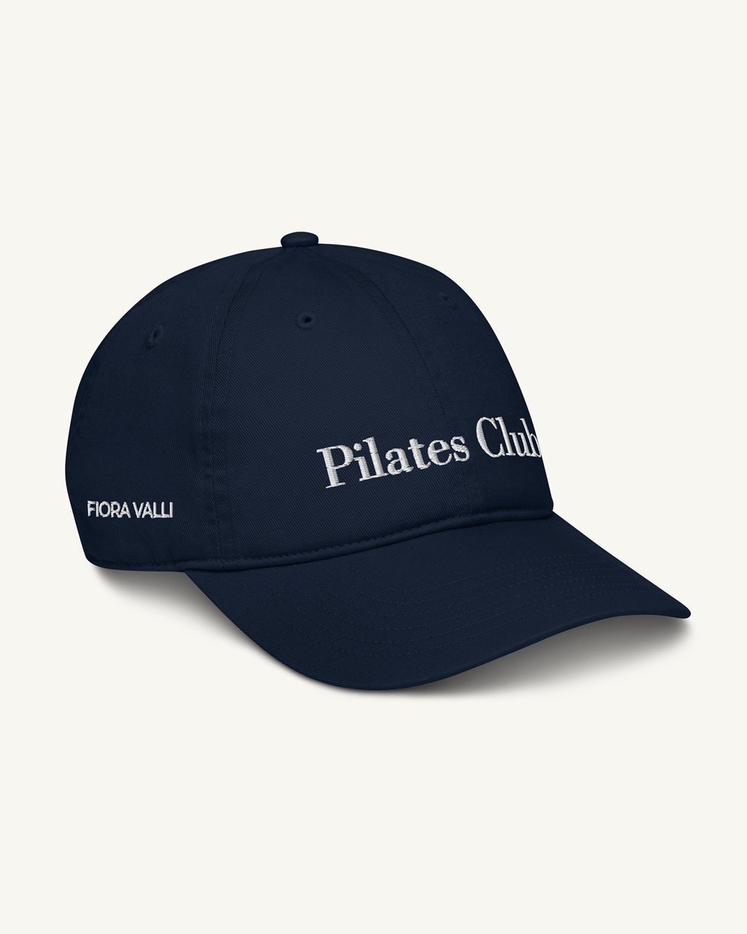 Navy blue cap with 'Pilates Club' text on a white background