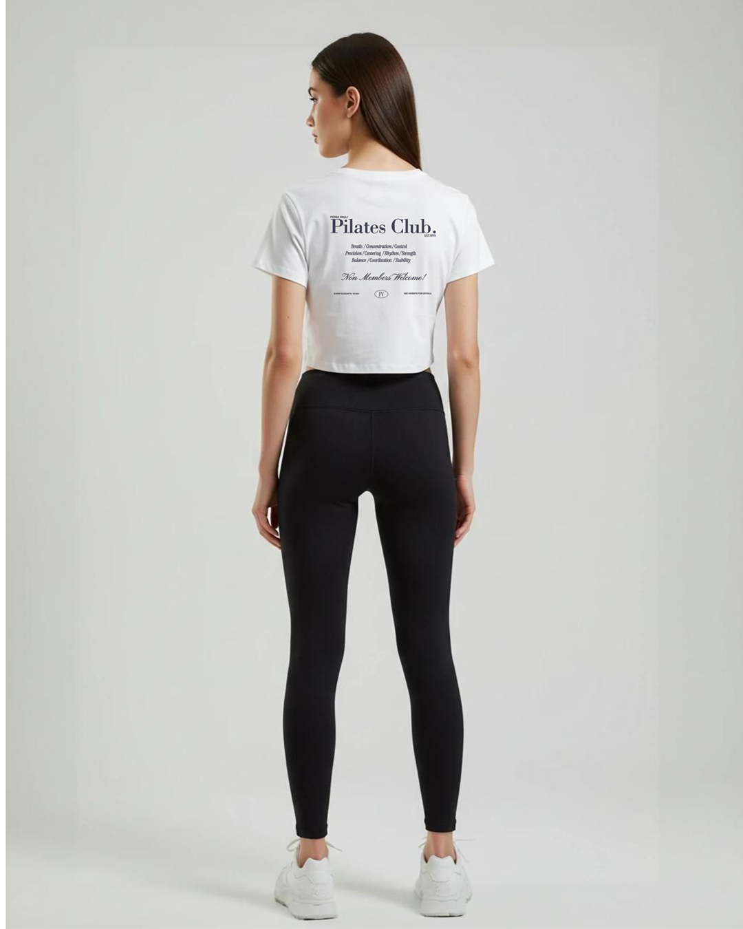 Person wearing a white 'Pilates Club' t-shirt and black leggings on a plain background