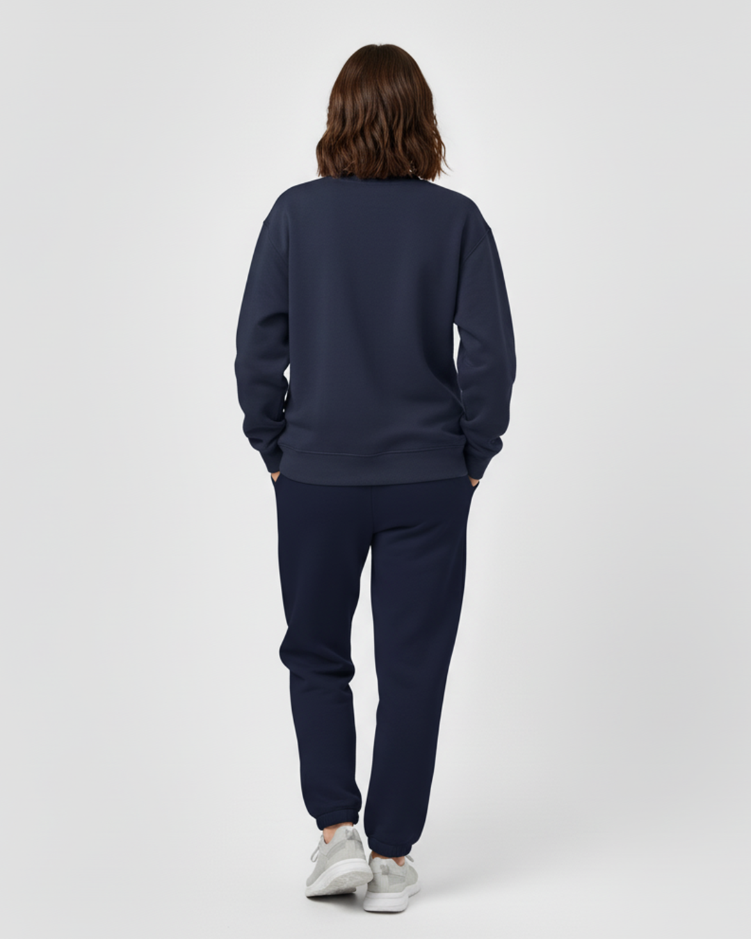 Person wearing a navy tracksuit on a white background