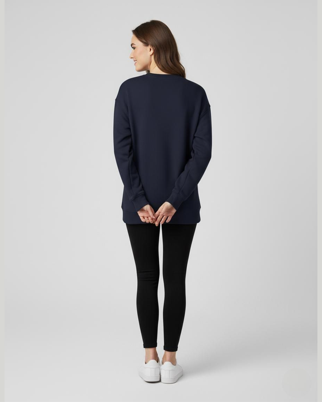 Woman wearing a navy blue sweater and black pants on a white background
